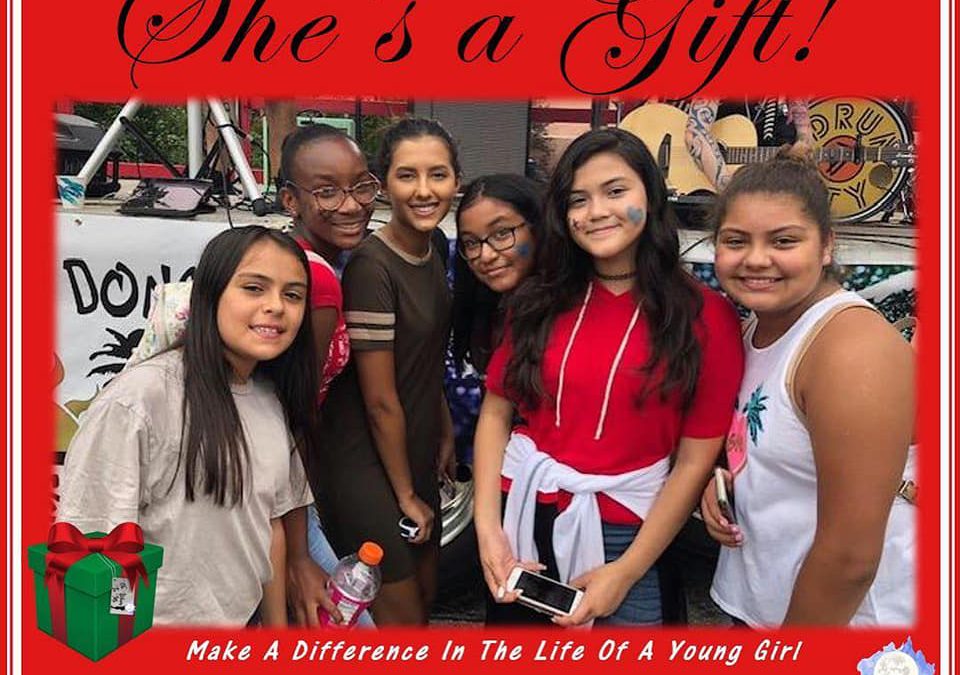 A group of pre-teen girls stands together, smiling. The graphc reads "December's Event: She's a Gift!" The even took place Saturday December 8th at Hutchison Elementary School